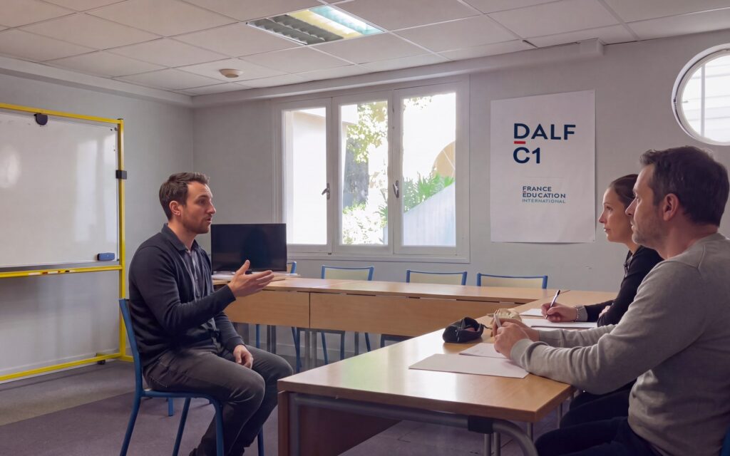 Prova orale del DALF all'Alliance Française di Salerno: il candidato davanti a due esaminatori, con il poster DALF C1 e il logo France Éducation international